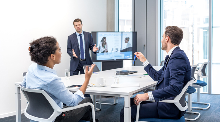 Future of Work @ BASF – Two men and a woman pointing at a screen (photo)